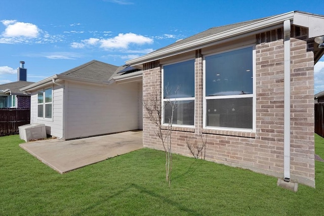 back of property with a yard and a patio