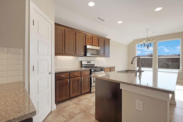 kitchen featuring appliances with stainless steel finishes, tasteful backsplash, sink, hanging light fixtures, and a center island with sink