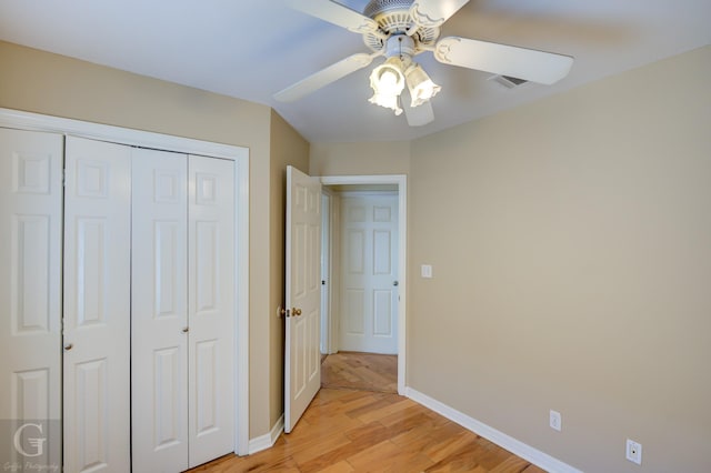 unfurnished bedroom with ceiling fan, light hardwood / wood-style floors, and a closet