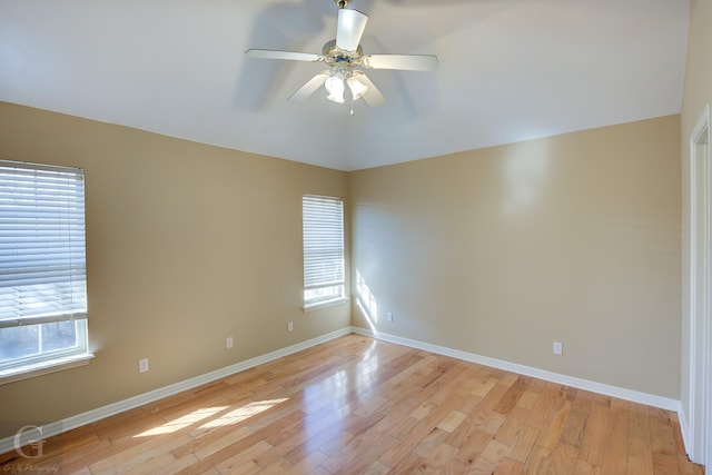 spare room featuring ceiling fan, a healthy amount of sunlight, and light hardwood / wood-style flooring