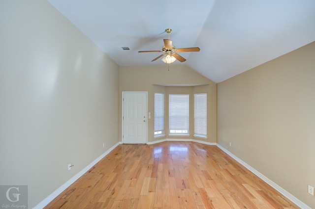 empty room with ceiling fan, lofted ceiling, and light wood-type flooring