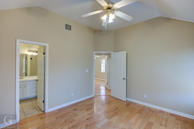 unfurnished bedroom with ceiling fan, ensuite bath, high vaulted ceiling, and light hardwood / wood-style floors