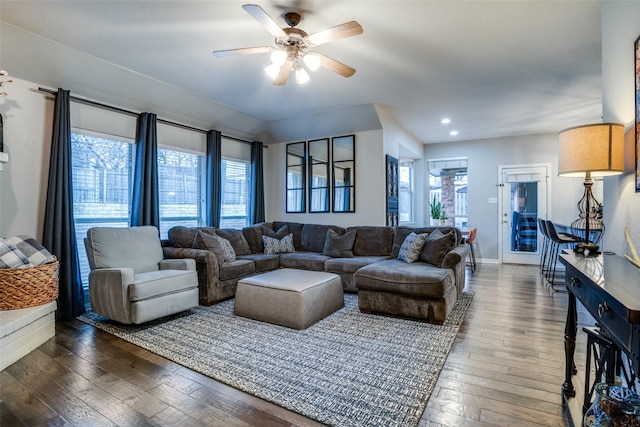 living room featuring dark wood-type flooring and ceiling fan