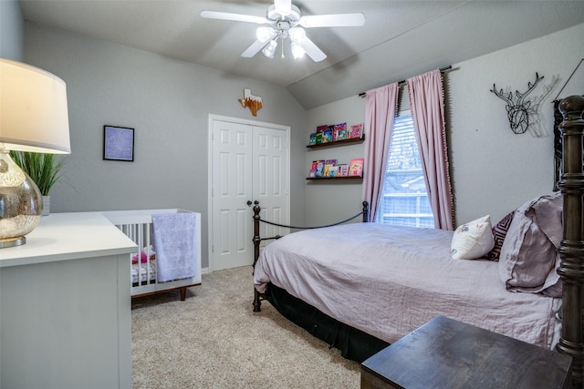 carpeted bedroom featuring ceiling fan, vaulted ceiling, and a closet