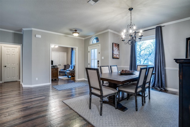 dining area featuring a notable chandelier, ornamental molding, dark hardwood / wood-style floors, and a textured ceiling