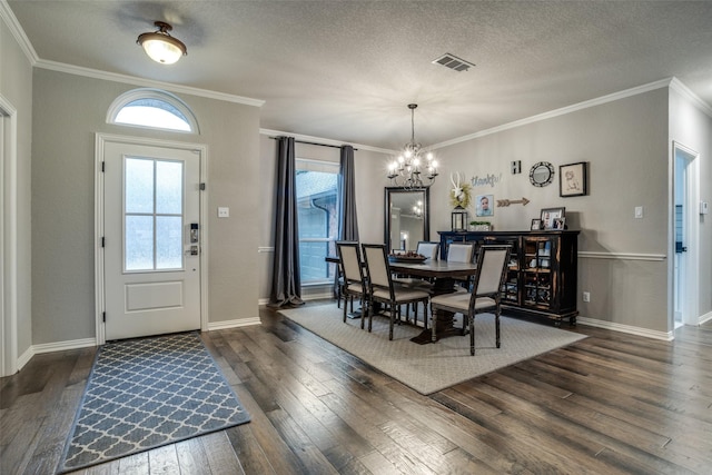 dining area featuring dark wood-type flooring, crown molding, an inviting chandelier, and a textured ceiling