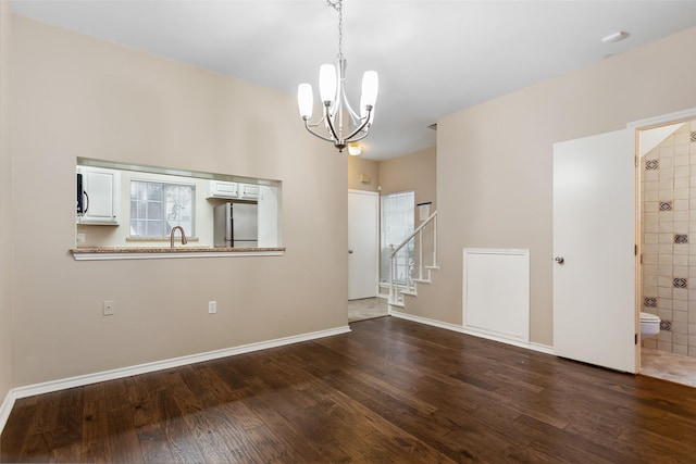 interior space with a wealth of natural light, dark wood-type flooring, sink, and a notable chandelier