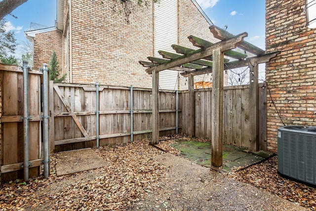 view of yard featuring central AC unit and a pergola