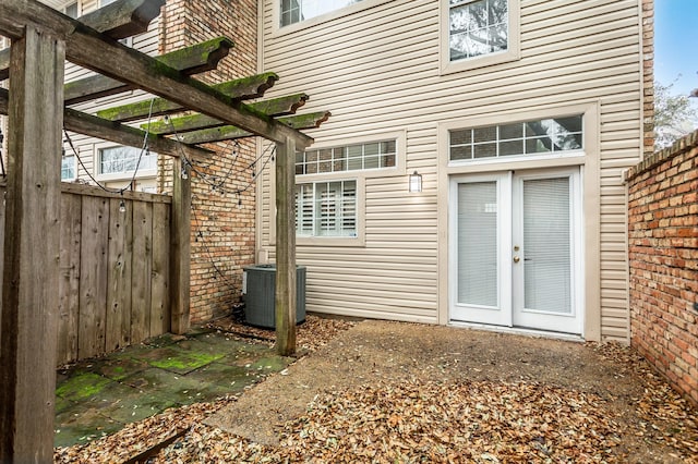 property entrance featuring a pergola, french doors, and central air condition unit