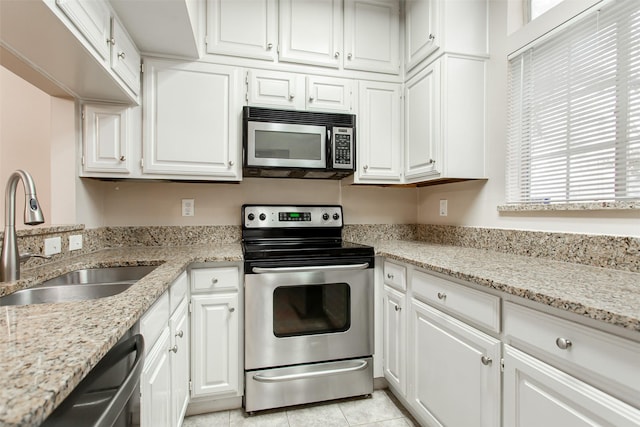 kitchen featuring white cabinetry, stainless steel appliances, light stone countertops, and sink