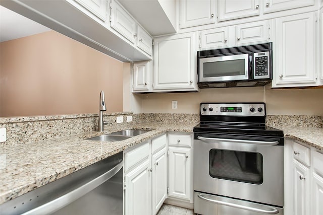 kitchen with stainless steel appliances, white cabinetry, sink, and light stone counters