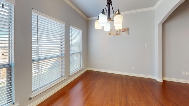 unfurnished dining area with crown molding, dark wood-type flooring, and an inviting chandelier