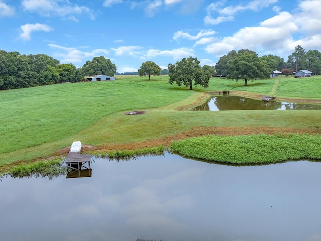 view of community featuring a lawn, a boat dock, and a water view