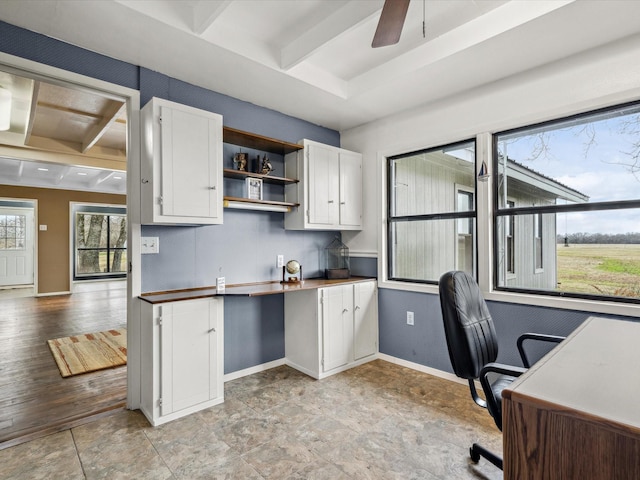 office area featuring built in desk, beamed ceiling, and ceiling fan