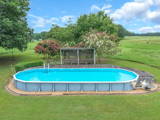 view of pool with a rural view and a lawn