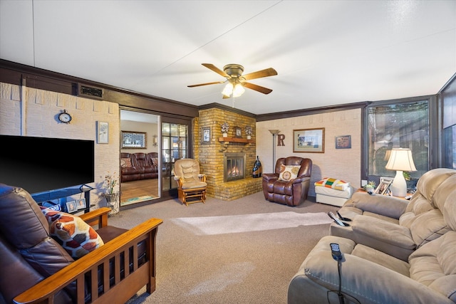 living room featuring ornamental molding, carpet flooring, ceiling fan, and a fireplace