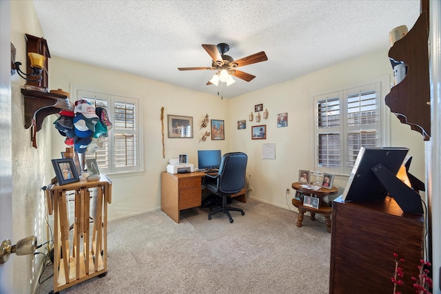 carpeted home office with ceiling fan and a textured ceiling