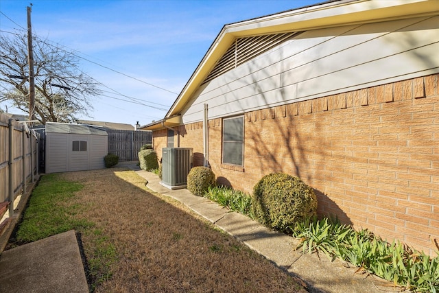 view of home's exterior with central AC and a storage shed