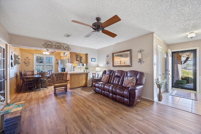 living room featuring ceiling fan, hardwood / wood-style floors, and a textured ceiling