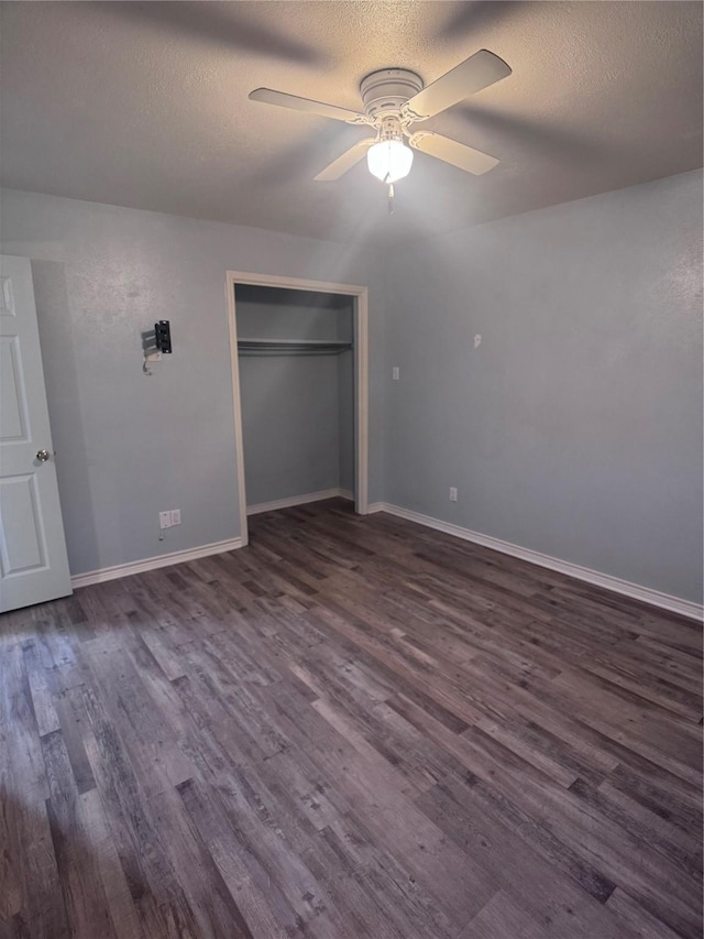 unfurnished bedroom featuring ceiling fan, dark hardwood / wood-style floors, and a textured ceiling