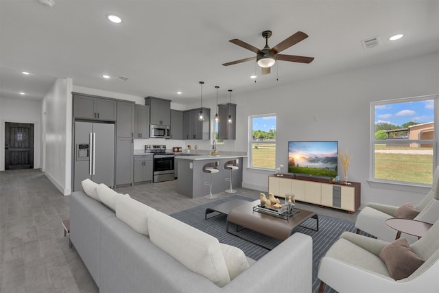 living room with light hardwood / wood-style flooring and ceiling fan