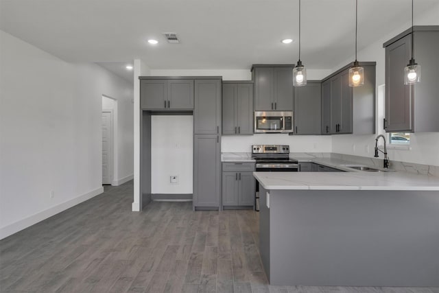 kitchen featuring sink, gray cabinets, appliances with stainless steel finishes, hanging light fixtures, and hardwood / wood-style floors