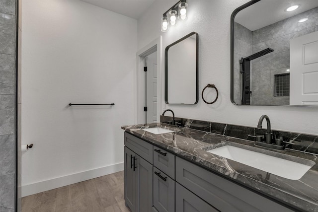 bathroom with walk in shower, vanity, and hardwood / wood-style floors