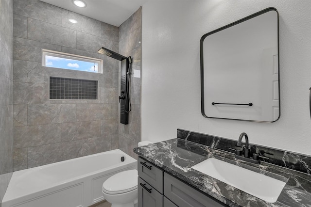 full bathroom with vanity, tiled shower / bath combo, and toilet