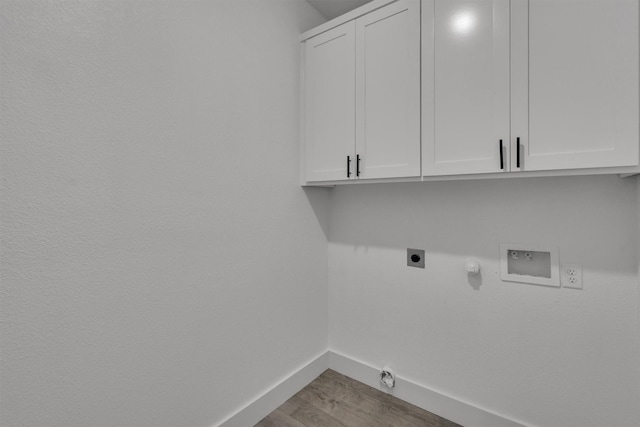 laundry area featuring gas dryer hookup, cabinets, washer hookup, electric dryer hookup, and light wood-type flooring