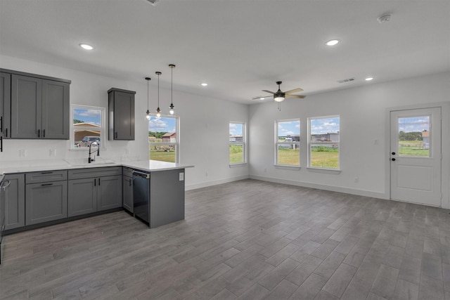 kitchen featuring gray cabinets, black dishwasher, sink, hanging light fixtures, and kitchen peninsula