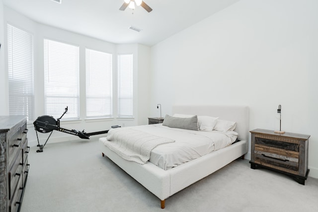 bedroom featuring visible vents, light colored carpet, and a ceiling fan