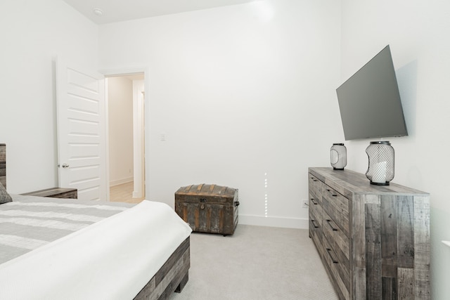 bedroom featuring baseboards and light colored carpet