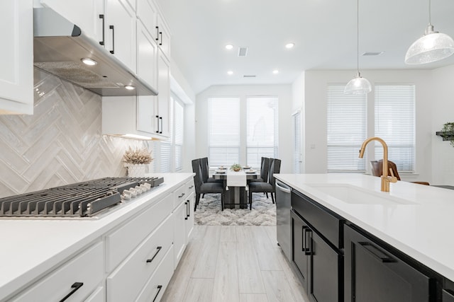 kitchen featuring under cabinet range hood, stainless steel appliances, light countertops, and a sink