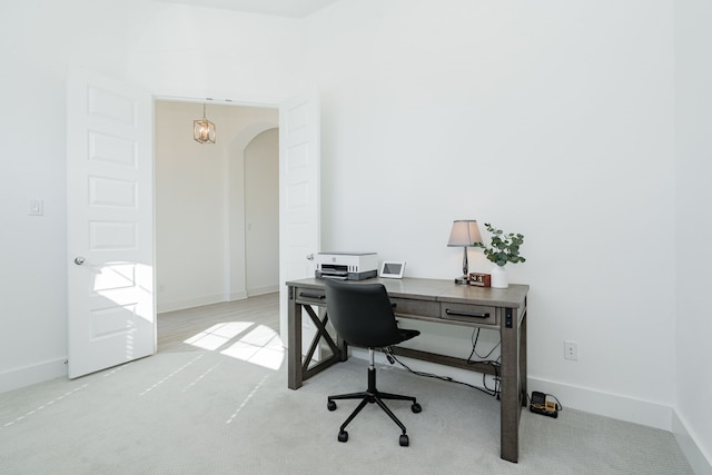 office space with arched walkways and baseboards