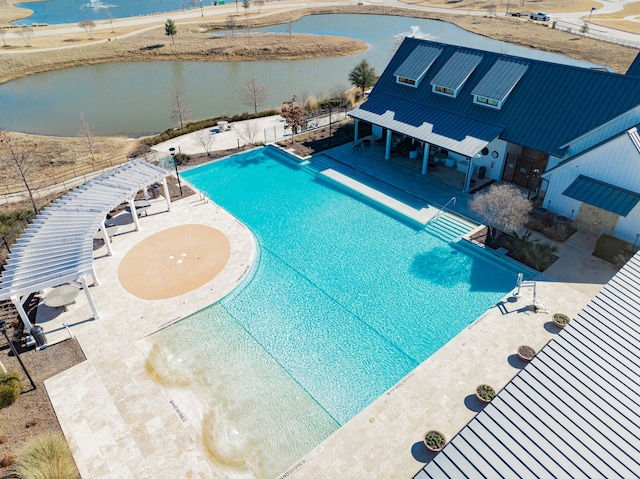 outdoor pool with a water view and a patio area