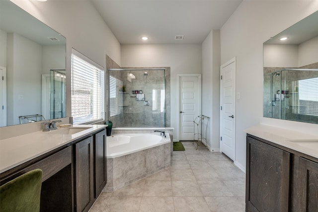 bathroom featuring independent shower and bath, vanity, and a healthy amount of sunlight