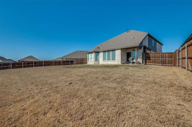 rear view of house featuring a lawn