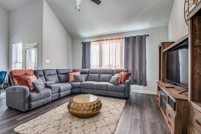 living room featuring dark wood-type flooring, ceiling fan, and a wealth of natural light