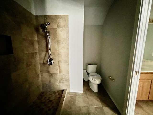 bathroom featuring toilet and a tile shower