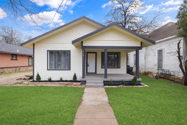 bungalow-style house featuring a porch, brick siding, and a front yard