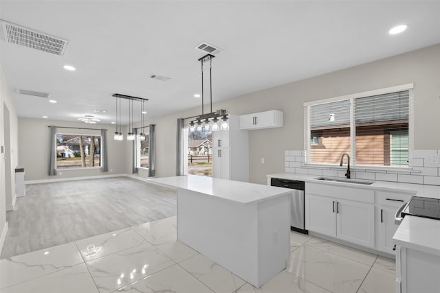 kitchen featuring sink, white cabinetry, a center island, hanging light fixtures, and stainless steel dishwasher