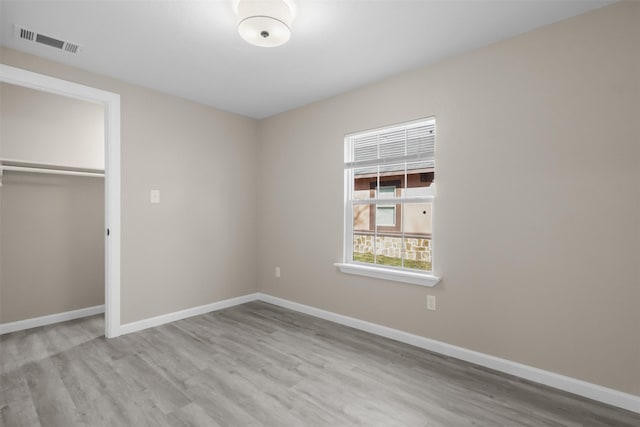 unfurnished bedroom with a closet and light wood-type flooring