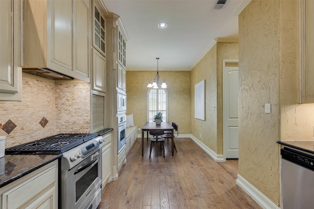 kitchen featuring appliances with stainless steel finishes, decorative light fixtures, a notable chandelier, crown molding, and light wood-type flooring