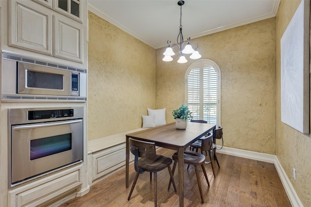 dining room featuring a notable chandelier, crown molding, and hardwood / wood-style flooring