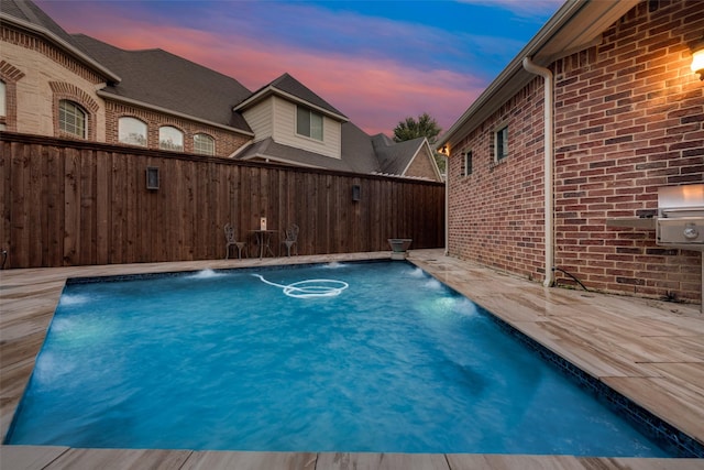 pool at dusk with pool water feature