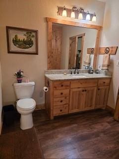 bathroom featuring vanity, hardwood / wood-style flooring, and toilet