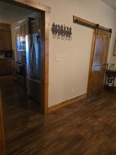 interior space with dark hardwood / wood-style floors and a barn door