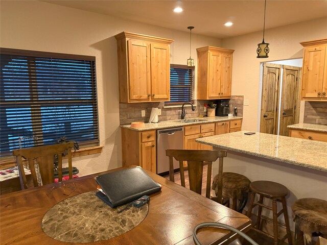 kitchen with pendant lighting, appliances with stainless steel finishes, dark hardwood / wood-style floors, a center island, and light stone counters