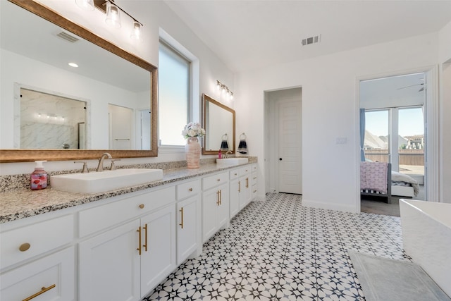 ensuite bathroom with visible vents, a sink, and ensuite bath