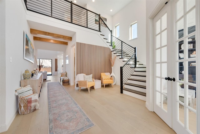 entryway featuring stairs, wood finished floors, a high ceiling, recessed lighting, and french doors